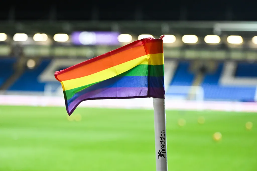 Rainbow flag planted on a football pitch.