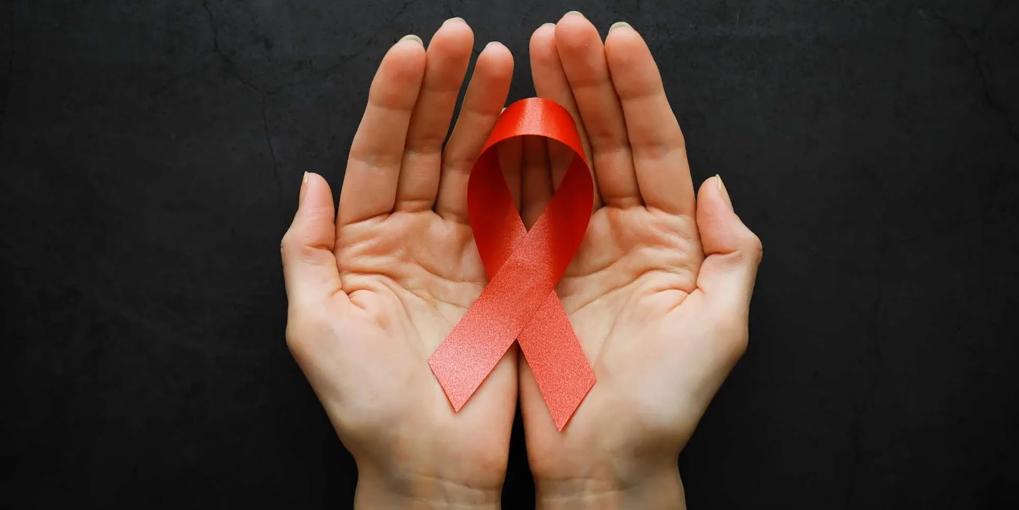 hands holding a red ribbon